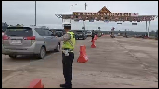 Personel Satlantas Polres Banyuasin mengatur arus kendaraan di jalan tol fungsional Musi–Pait menuju Pulau Rimau
