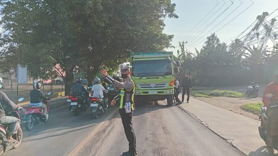 Petugas Satlantas Polres Banyuasin mengatur arus lalu lintas saat truk mogok di Jalintim KM 16 Simpang Pasir Putih, Kecamatan Talang Kelapa.